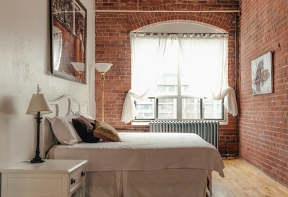 Urban loft style bedroom with brick accent wall
